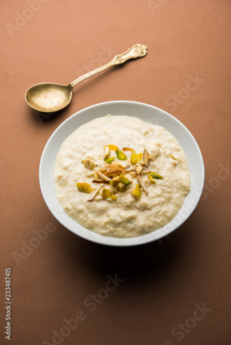 Sweet Rabdi or Lachha Rabri or basundi, made with pure milk garnished with dry fruits. Served in a bowl over moody background. Selective focus