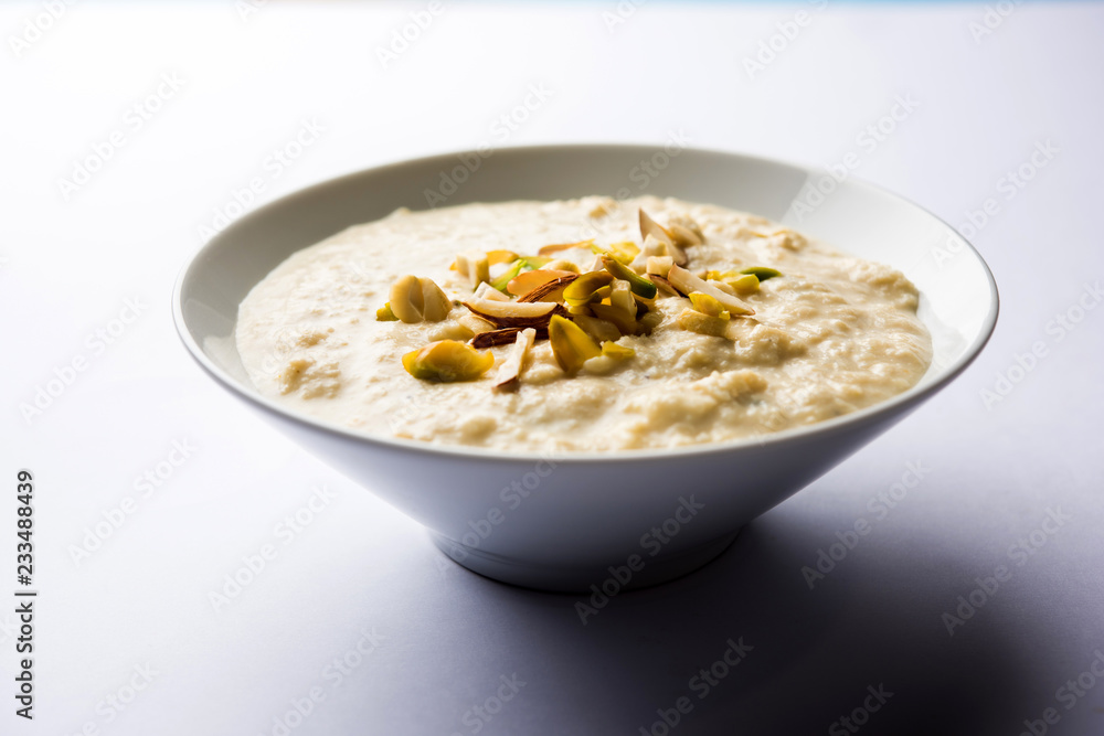 Sweet Rabdi or Lachha Rabri or basundi, made with pure milk garnished with dry fruits. Served in a bowl over moody background. Selective focus Sweet Rabdi or Lachha Rabri or basundi, made with pure milk garnished with dry fruits. Served in a bowl over moody background. Selective focus