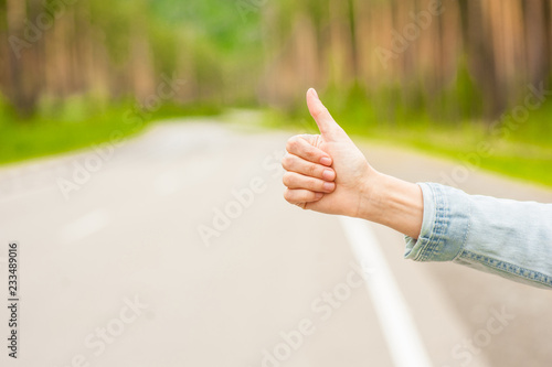 Canvastavla girl hitchhiking hand in travel time on road background