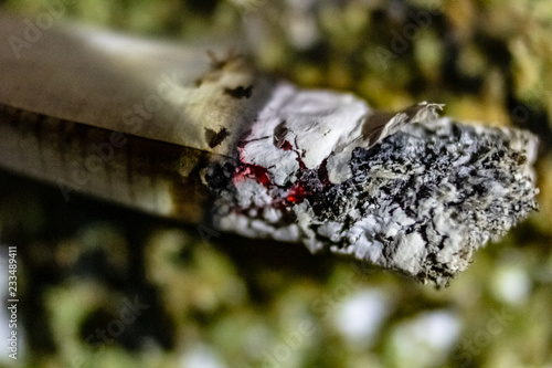 Obraz na płótnie The tip of a marijuana joint close up burning over ground marijuana w salonie