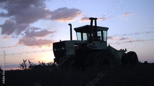 Slow sideways panning movement while big old tractor starts up early in the morning.