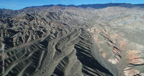 Aerial drone scene of desertic colorfull folded hills made of sand and rock and dry rivers and gullies. High view, panoramic view of mountains. San Juan, Calingasta photo