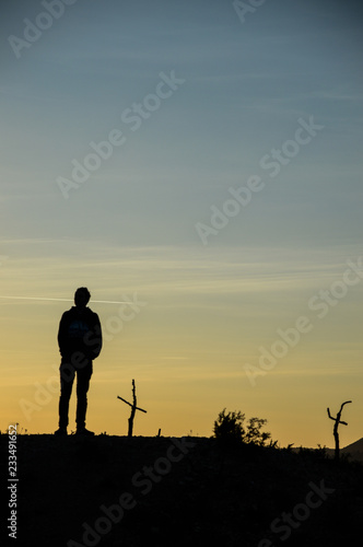 Man silhouette standing alone in sunset