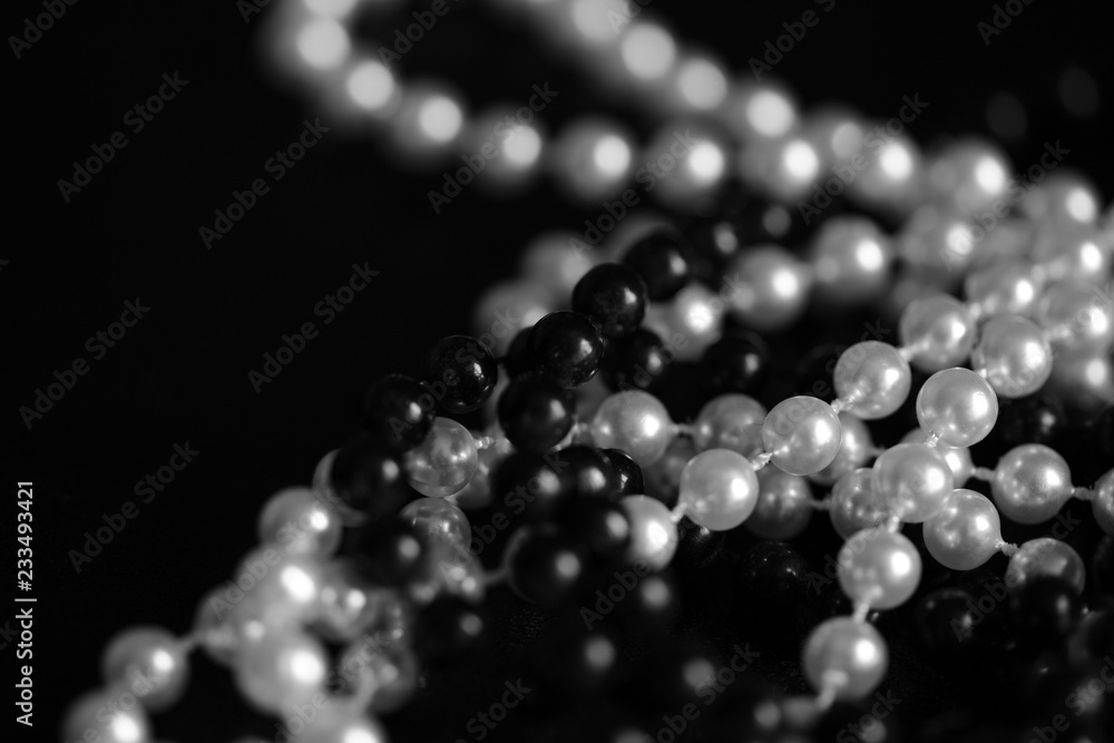 Necklace of black and white beads on a dark background close up. Black and white Necklace of black and white beads on a dark background close up. Black and white