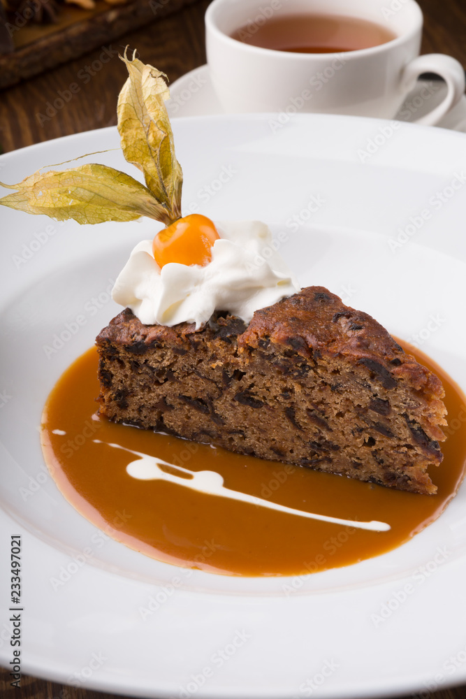Slice of chocolate cake served with cupt tea and mint Slice of chocolate cake served with cupt tea and mint