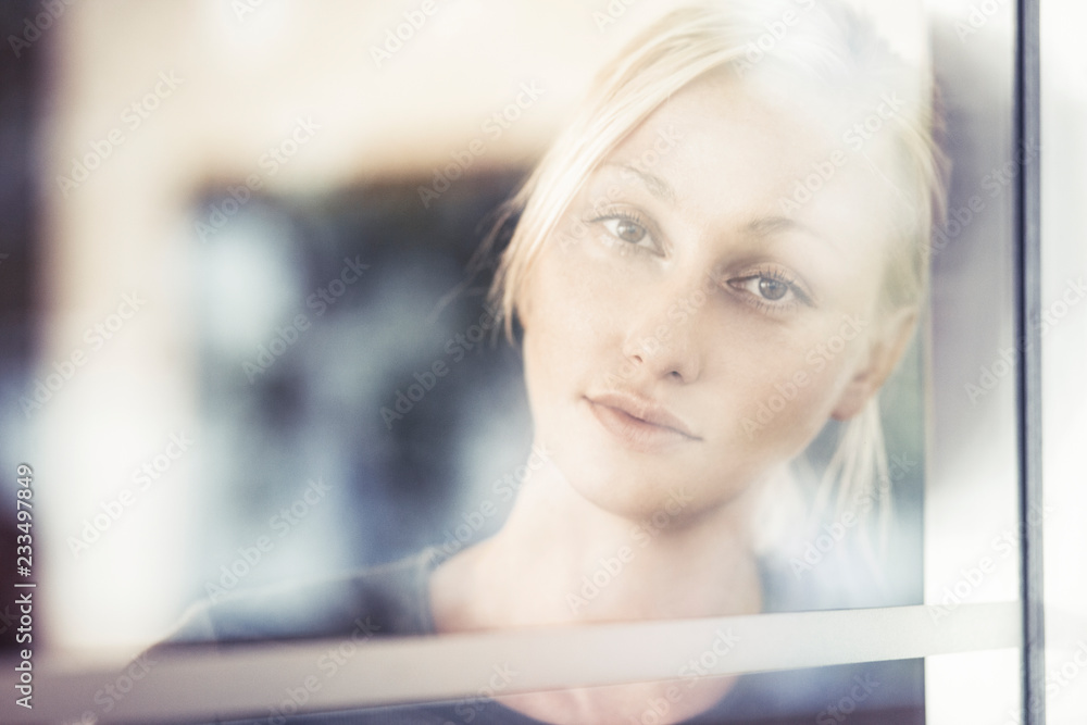 Sad beautiful woman looking out window Sad beautiful woman looking out window