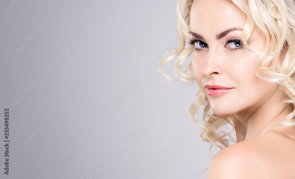 Fototapeta premium Beauty portrait of attractive blond woman with curly hair and a beautiful hairstyle. Makeup and cosmetics, face lifting and beauty concept.