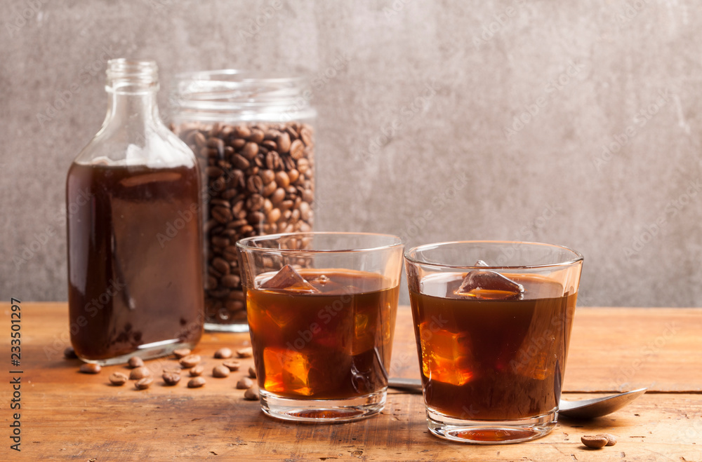 Cold brew coffee and coffee jar on the wooden table. Cold brew coffee and coffee jar on the wooden table.