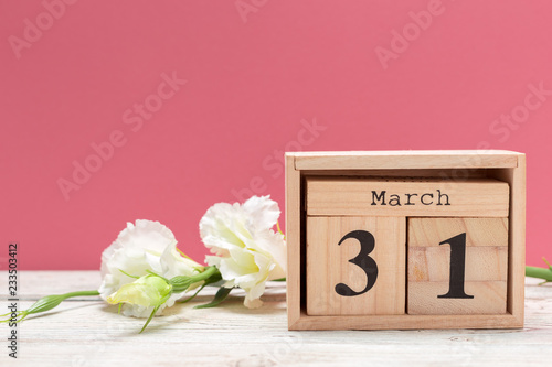 wooden cube shape calendar for march 31 on wooden tabletop
