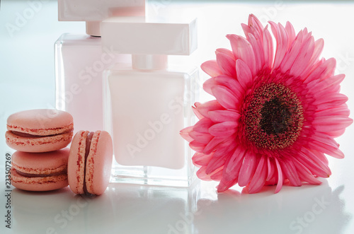 Beautiful pink perfume bottles with flower and macaroons.  Luxury perfumery background photo