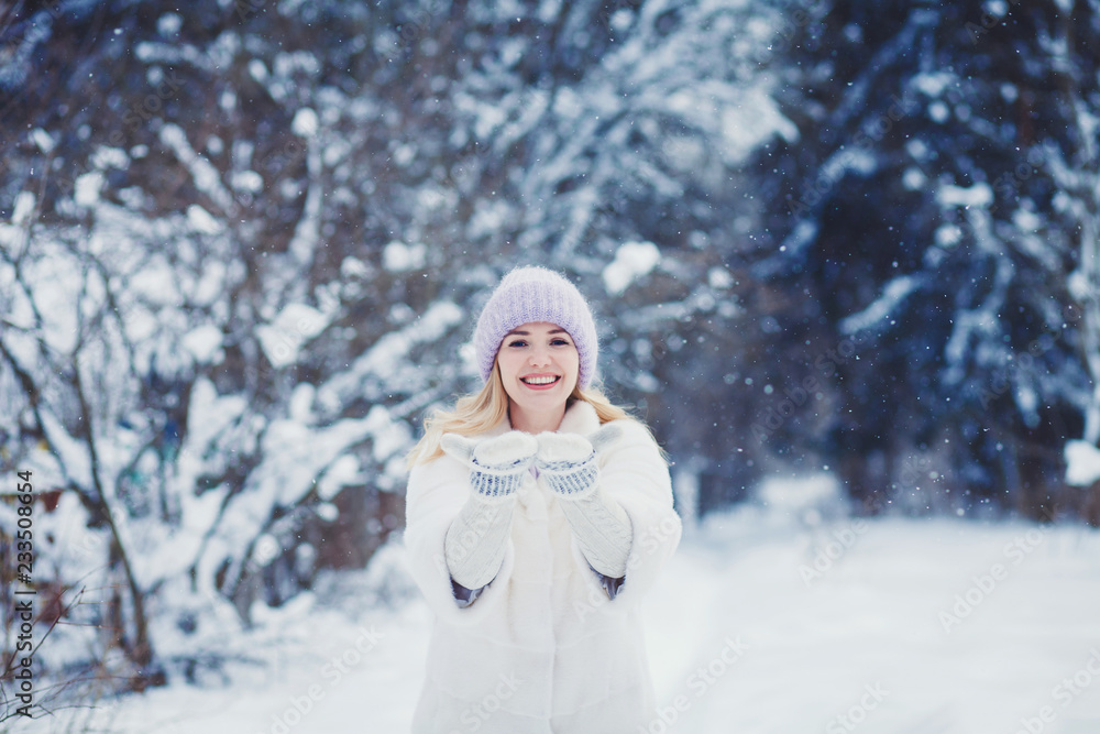 Smiling woman playing with snow in park Smiling woman playing with snow in park