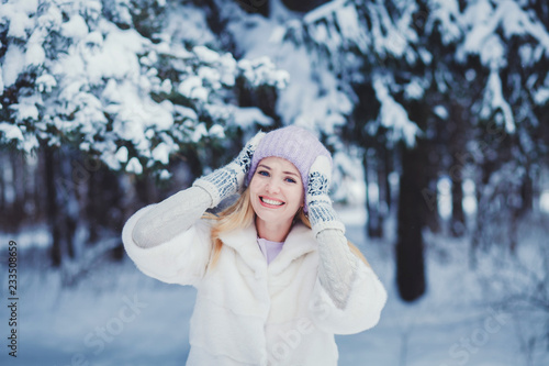 Winter portrait of a smiling woman in a hat and mittens. New Year