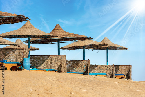 Fototapeta Naklejka Na Ścianę i Meble -  Straw Beach Umbrellas and Deck Chairs - Red Sea Egypt