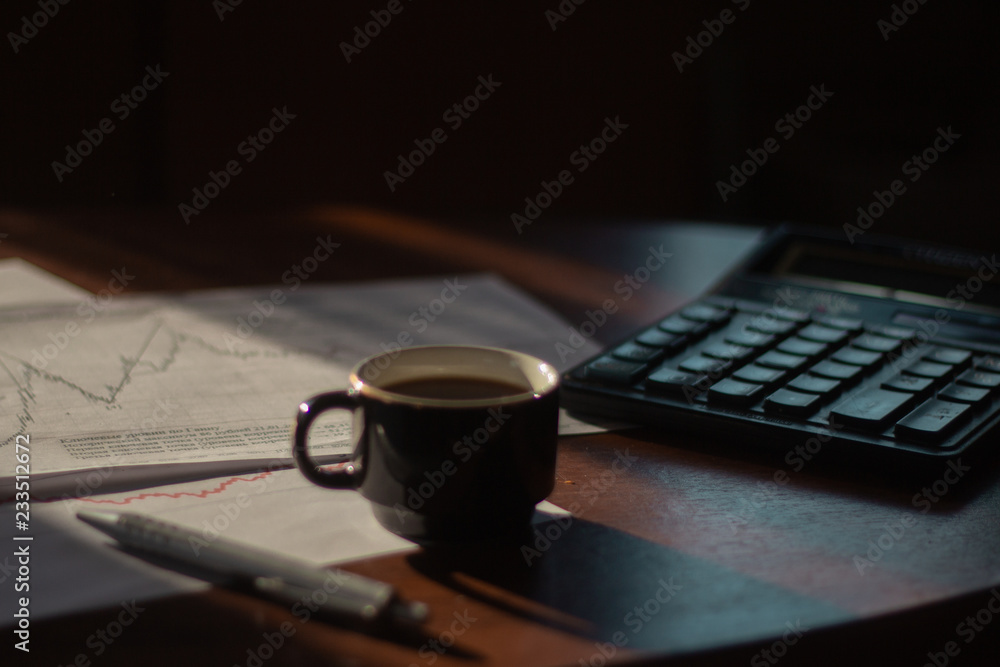 Morning cafe.On the table are graphs and a pen with a calculator. Morning cafe.On the table are graphs and a pen with a calculator.