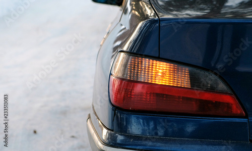 Close-up alarm flashes on the left side of the vehicle in winter park. Back view from the side.