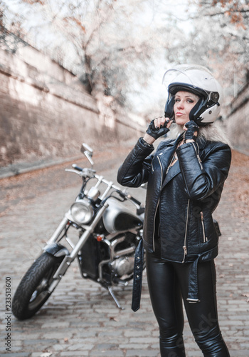 Stylish blond woman with motorcycle outdoor. 