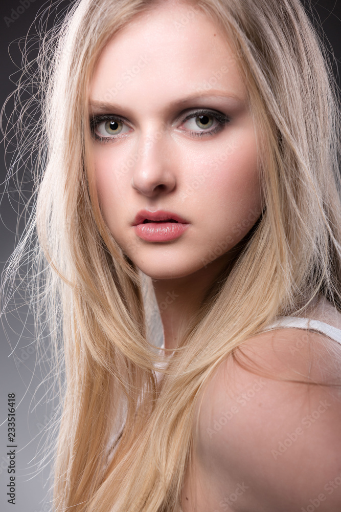 Portrait einer hübschen blonden Frau vor grauem Hintergrund Portrait einer hübschen blonden Frau vor grauem Hintergrund