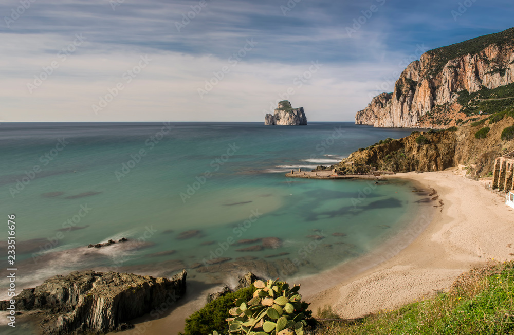 Suggestiva cornice scenografica dell'insenatura di Masua, con vista sull’Imponente roccia del Pan di Zucchero, lungo la costa dell’Iglesiente a sud ovest della Sardegna, Italia.