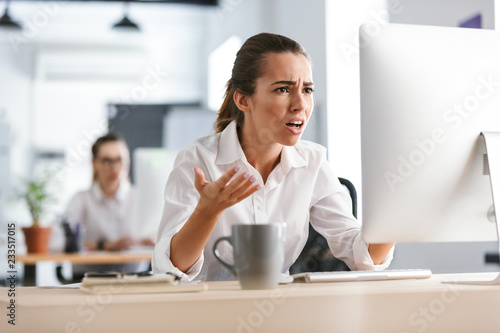 Confused young business woman work in the office with computer.