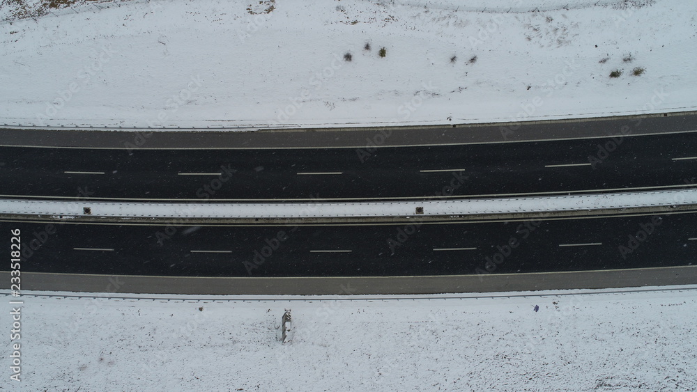 aerial top view of highway with low traffic on snowy winter day aerial top view of highway with low traffic on snowy winter day