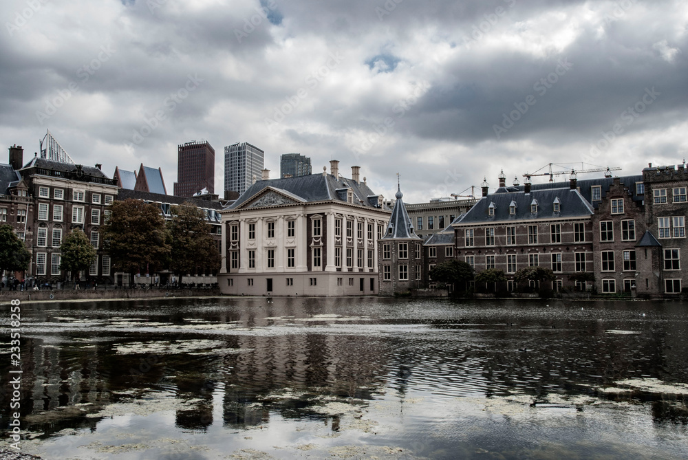 Fototapeta premium kyline of The Hague with the modern office buildings behind the Mauritshuis museum and the Binnenhof parliament building next to Hofvijver lake. 