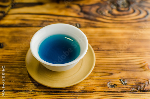 Organic blue tea Anchan in a teapot and a cups on wooden background