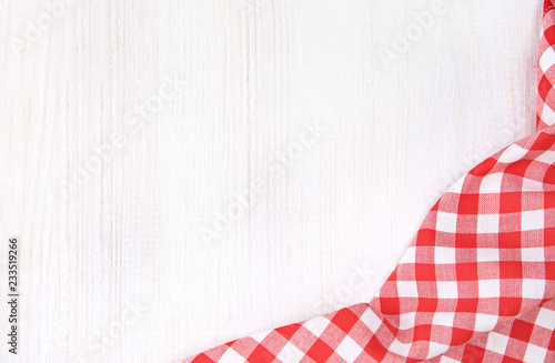 Kitchen red checkered table cloth frame on white wooden empty space background.