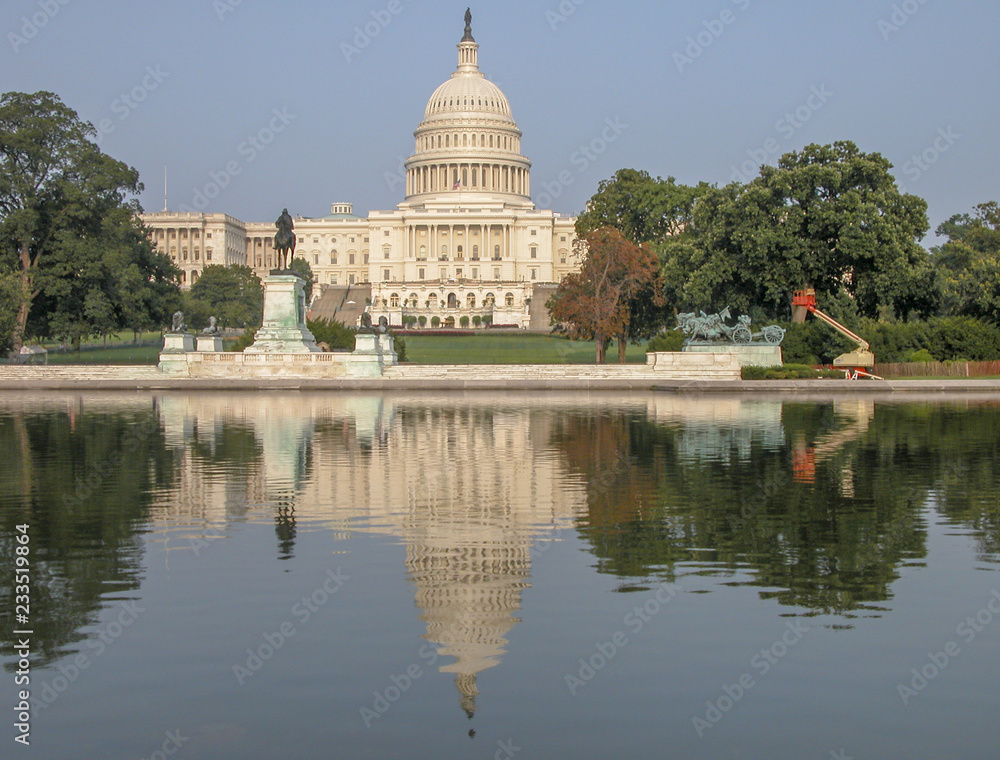 West side of the United States Capitol Building in Washington, DC. Landmark with trees and lake on a sunny day