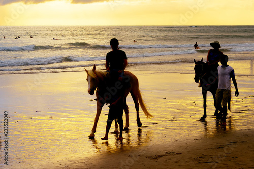 tourists riding horses on b...