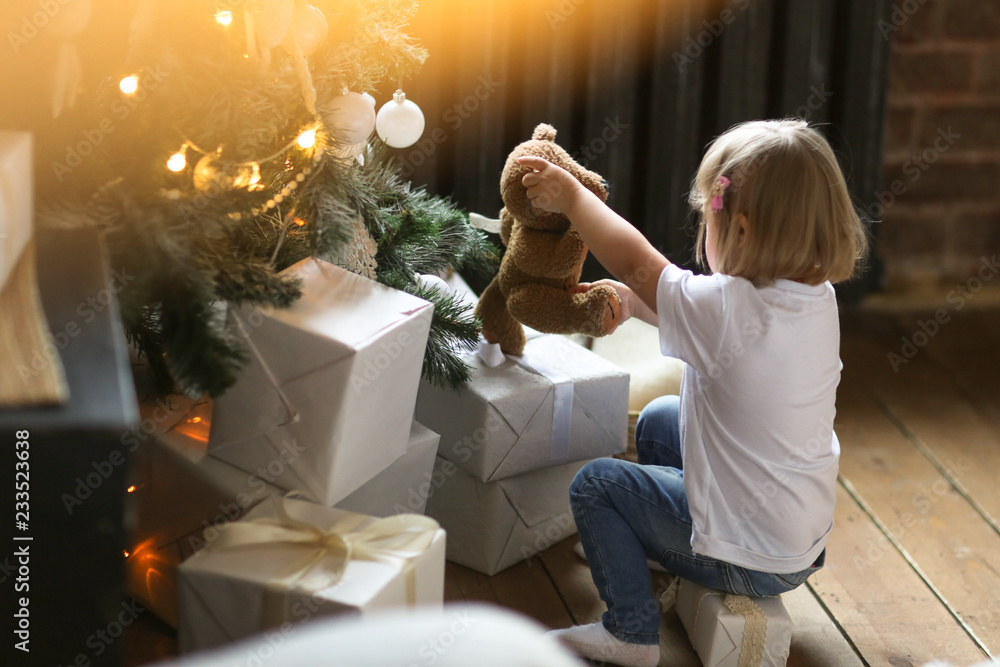 child near a New Year tree plays with gifts child near a New Year tree plays with gifts