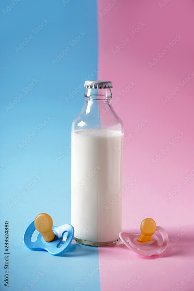 Bottle of milk and pacifiers on color background Bottle of milk and pacifiers on color background