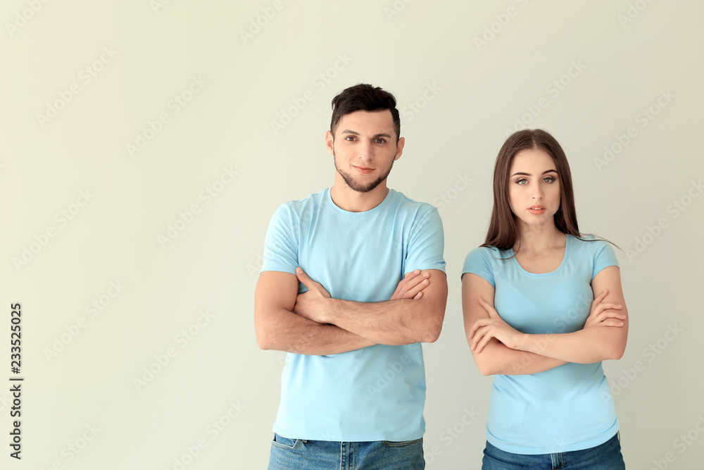 Young man and woman in stylish t-shirts on white background Young man and woman in stylish t-shirts on white background