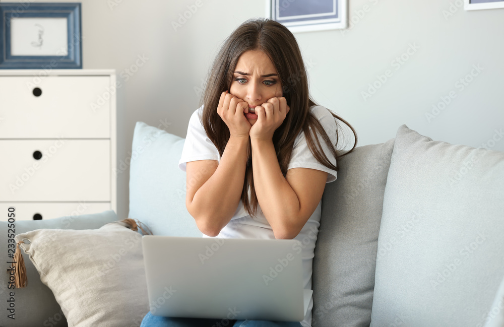 Emotional young woman after making mistake during work on laptop at home Emotional young woman after making mistake during work on laptop at home