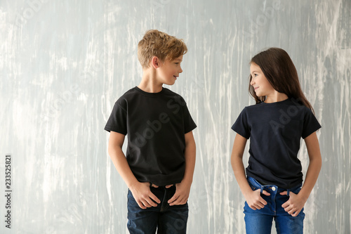 Cute children in t-shirts on grey background