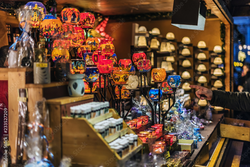 Vienna, Austria - December 24, 2017. Lighting colorful glass candle holders in kiosk at Viennese Christmas market. Close view of Xmas fair stall selling craft gifts and souvenirs.