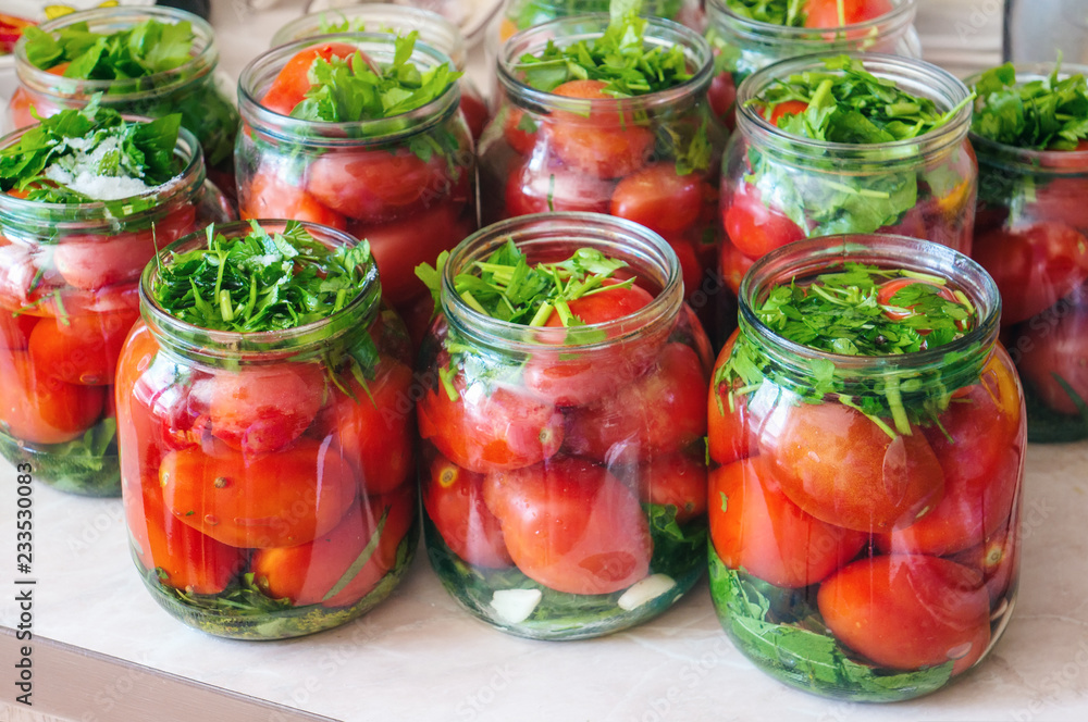 Fermenting vegetables with lots of greens in glass jars. Processing the harvest of tomatoes from home garden Fermenting vegetables with lots of greens in glass jars. Processing the harvest of tomatoes from home garden