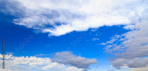 Blue sky with white cumulus clouds. Abstract natural background. Perfect summer day in the countryside.