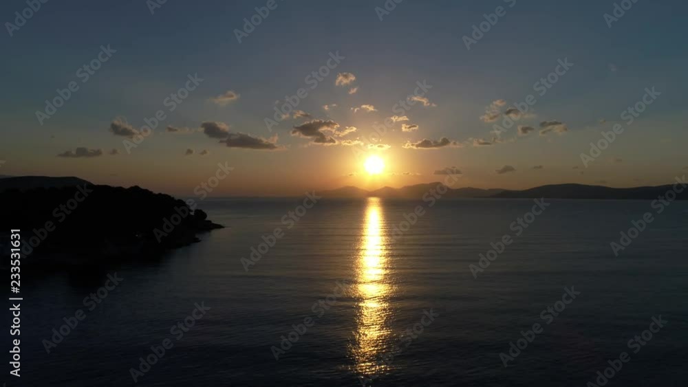 Aerial view. Beautiful sunrise from behind the mountains on the horizon above the calm sea. The camera moves at a small height from the surface of the water. Aerial view. Beautiful sunrise from behind the mountains on the horizon above the calm sea. The camera moves at a small height from the surface of the water.