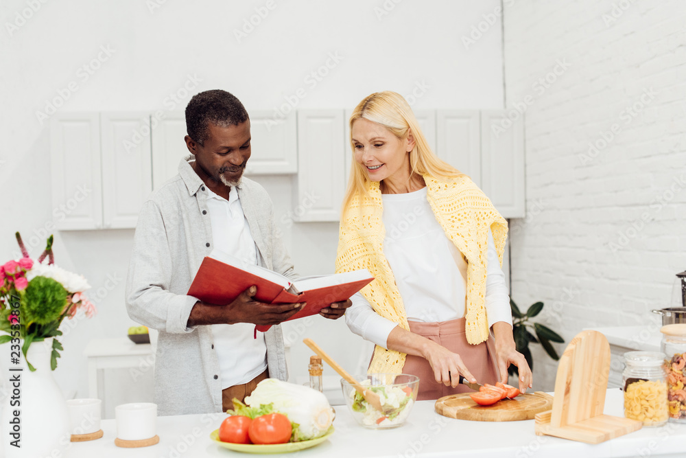 happy couple cooking dinner together at kitchen