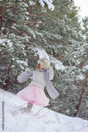little girl looks at a snowy branch