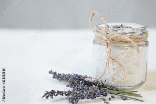 Natural herbal sea salt with aromatic lavender - perfect for relaxation. Cosmetic jars and bottles with salt, lavender flowers photo