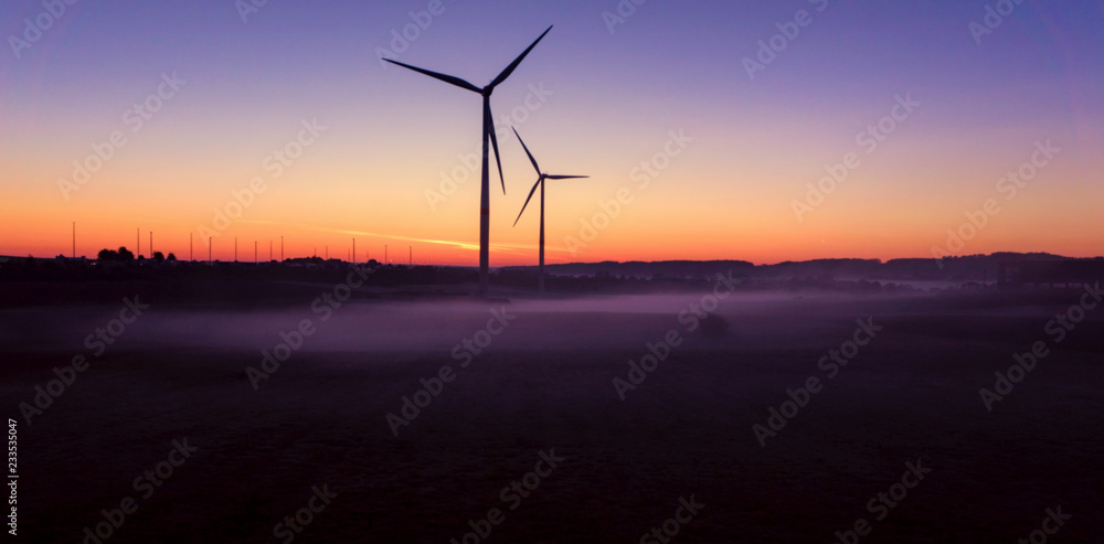 Obraz premium Windmill at Sunset . Wind turbines farm . Wind turbines farm at sunset