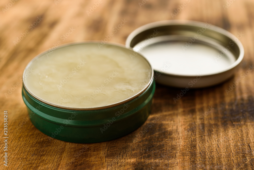 Organic balm in open small metal can, lid to the side. Organic balm in open small metal can, lid to the side.