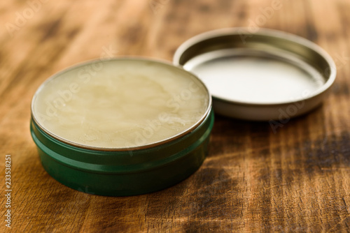 Organic balm in open small metal can, lid to the side. photo