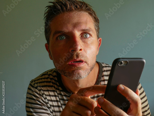 фотографія young weird and crazy mobile phone addict man using cell compulsively with weird