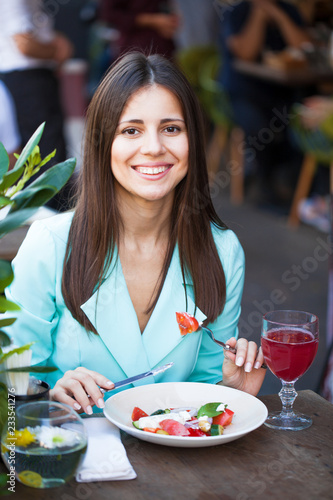 Young beautiful woman is having breakfast in a cafe