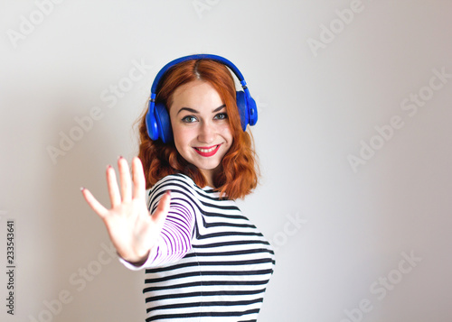 Fashion pretty girl listening to music in headphones wearing a striped sweater. Music, lifestyle concept. © Photo-Che