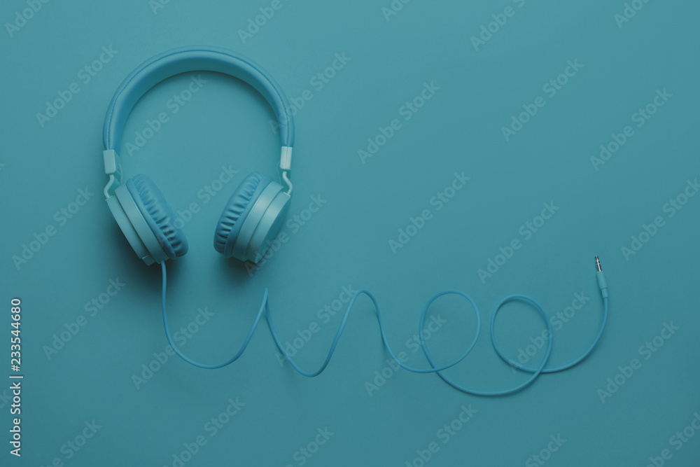 Blue headphones on blue background. Music concept Blue headphones on blue background. Music concept