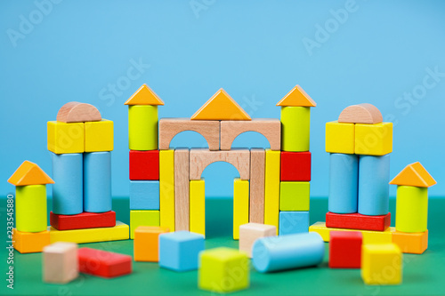 Different color and shape wooden toy blocks on colorful background.