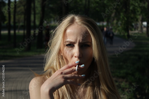 young blonde girl who smokes a cigarette